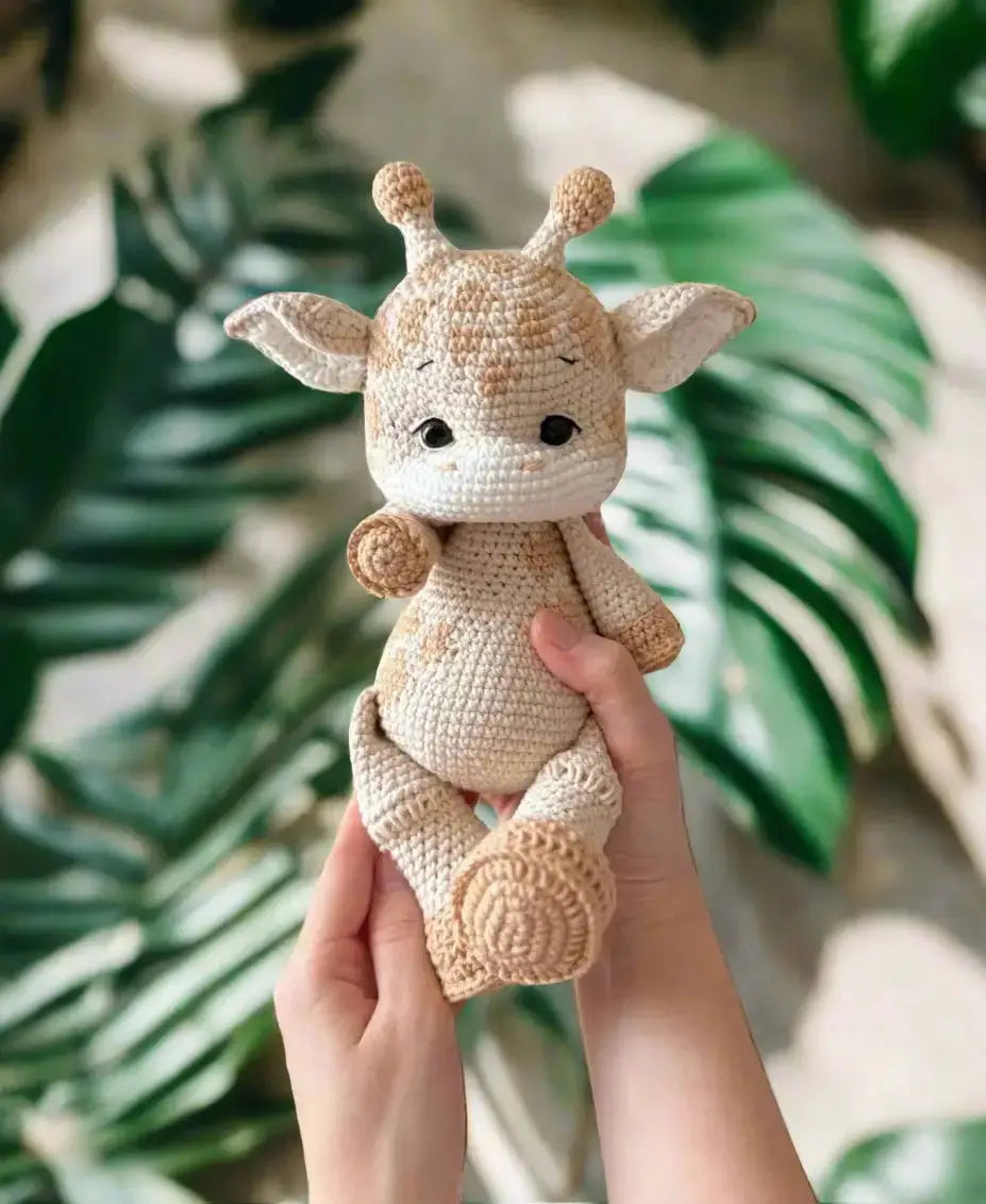 Crocheted giraffe stuffed animal held up against leafy green background