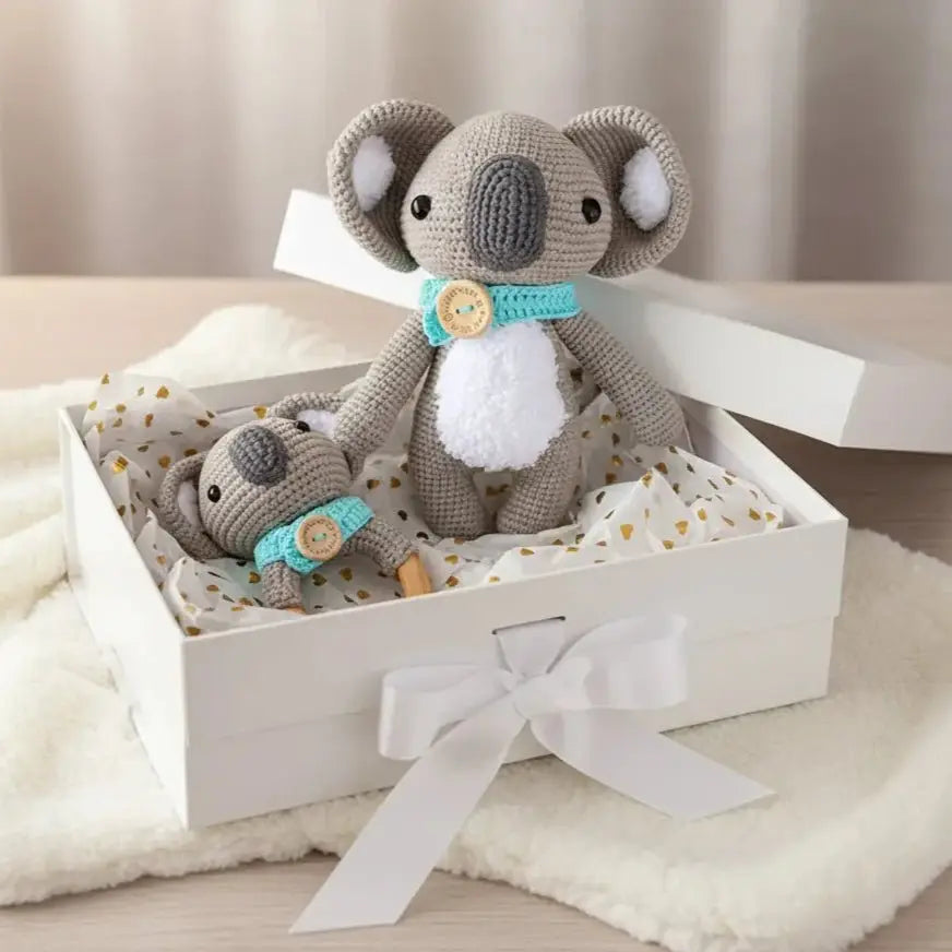 Crocheted koala parent and baby in gift box with blue ribbons and bow