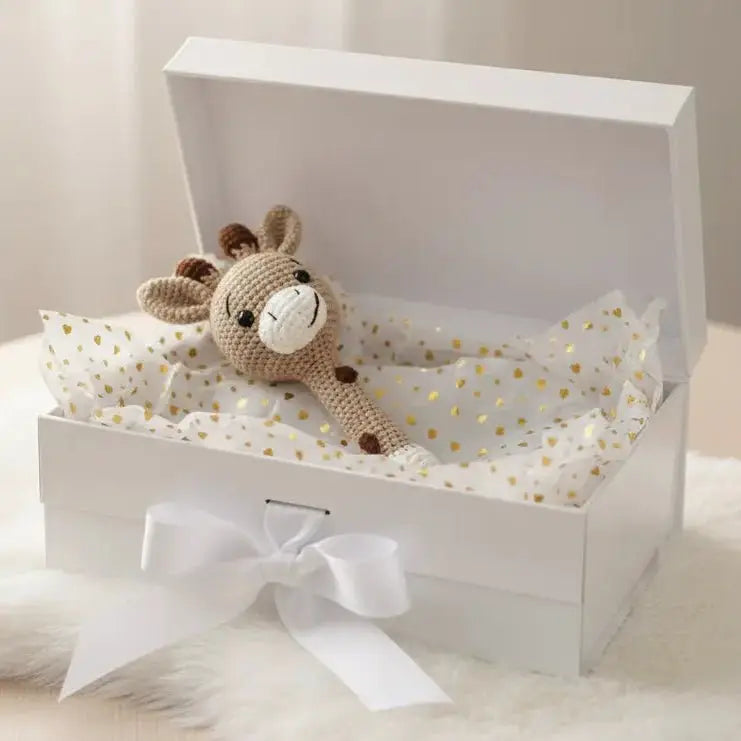 Crocheted bunny nestled in a white gift box with gold-dotted tissue paper and a bow