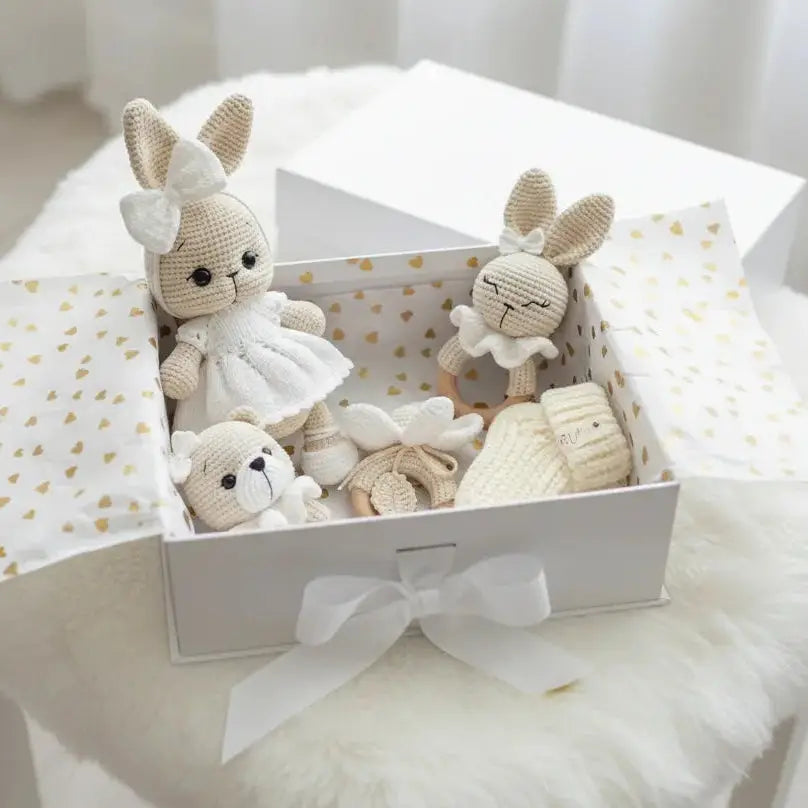 Crocheted bunny dolls and bear in white gift box with golden hearts pattern