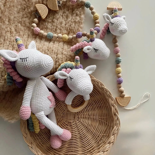 Crocheted white unicorns with pastel manes on woven basket and wooden beaded garland