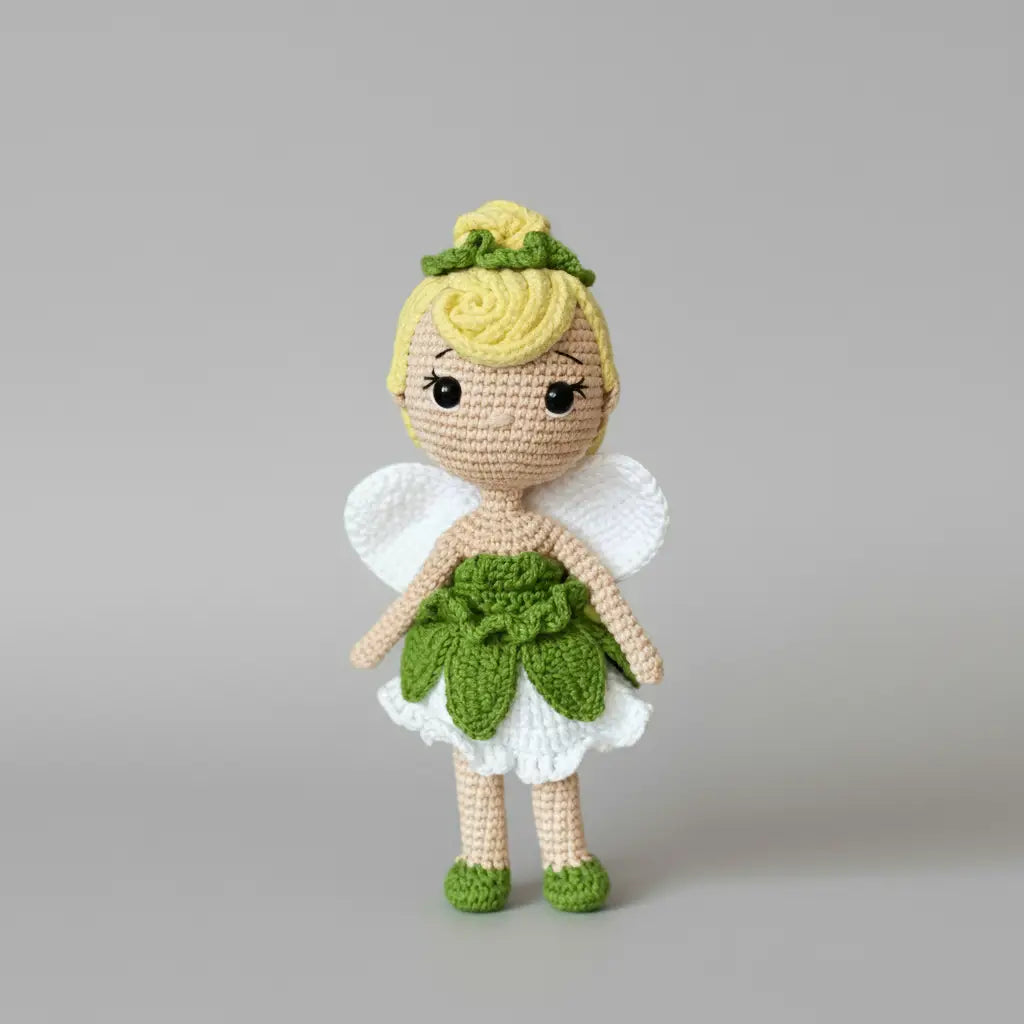 Crocheted fairy doll with yellow hair, white wings, and green leaf-like dress and shoes