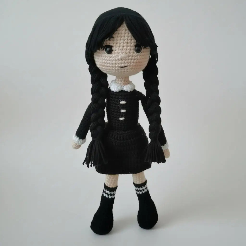 Crocheted doll with black braids wearing a dark dress and white collar