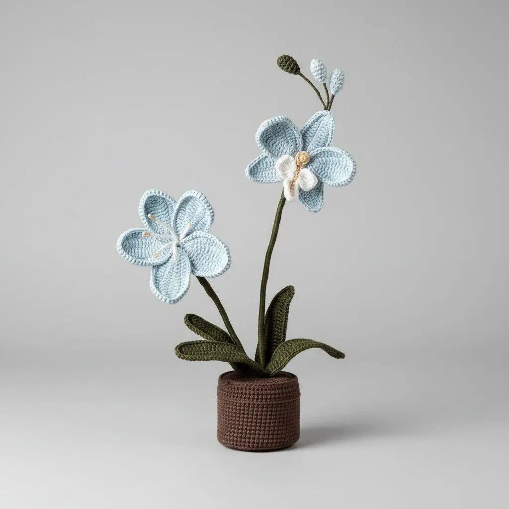 Crocheted blue orchid with green leaves in a brown knitted pot on gray background