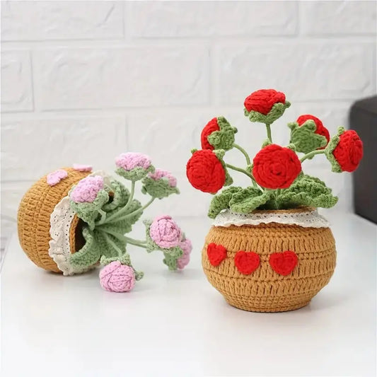 Crocheted rose flower pots with pink and red roses on white brick background