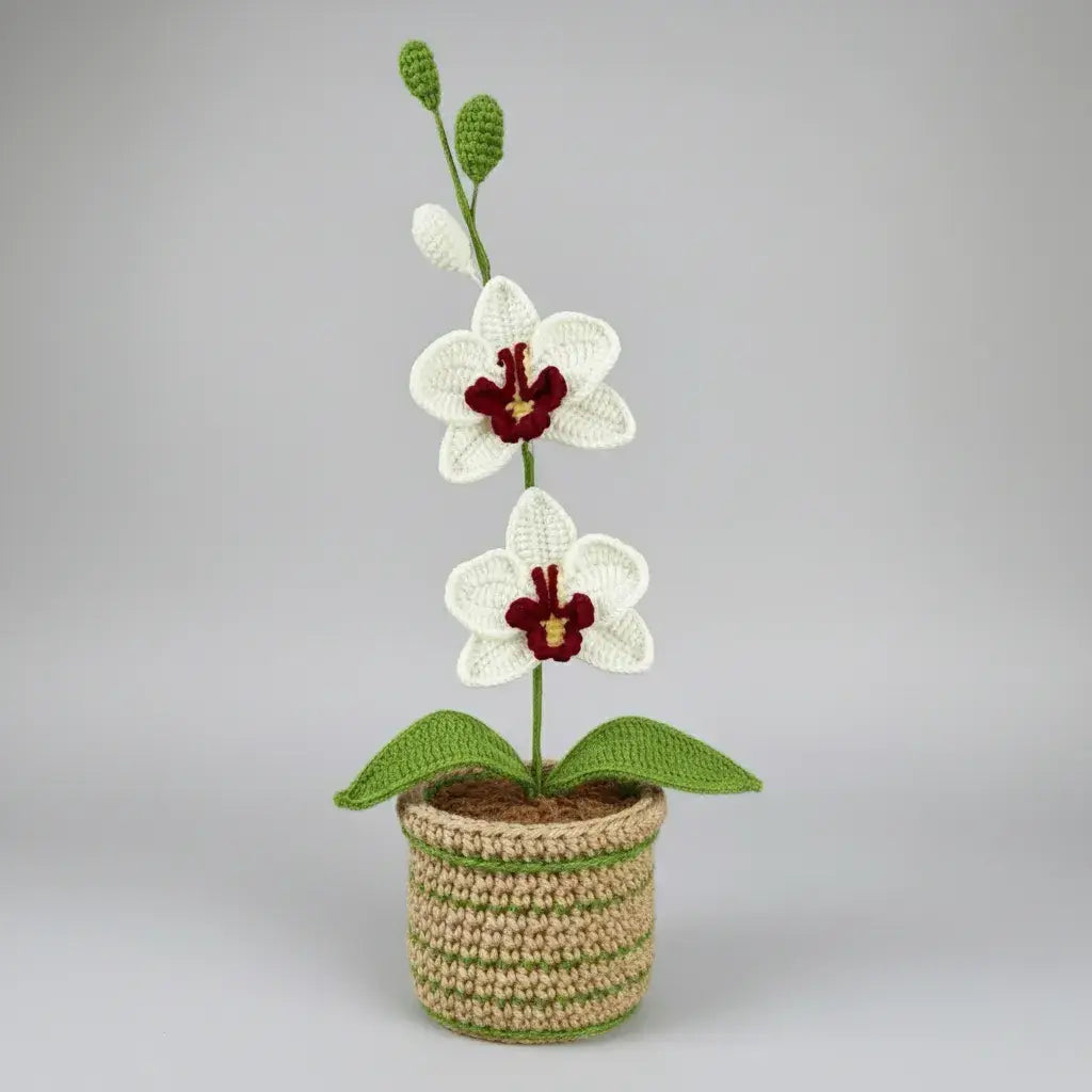Crocheted white orchid with red center in striped beige and green pot