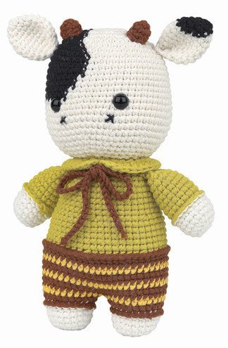 Crocheted cow plush toy wearing yellow sweater and striped brown pants
