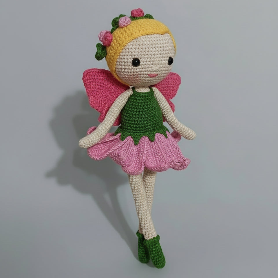 Crocheted flower fairy doll with pink wings and green dress, yellow headband