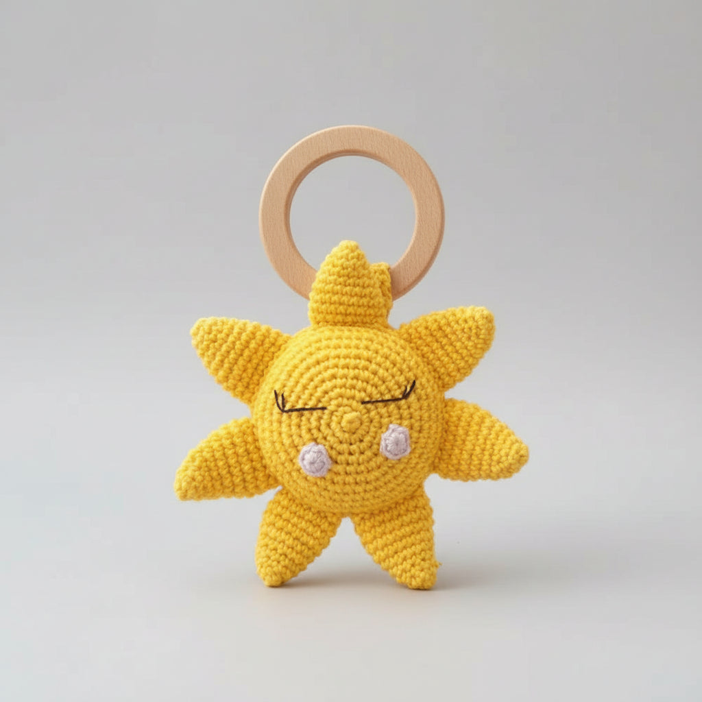 Crocheted yellow sun-shaped baby teether with wooden ring, cute sleepy face design