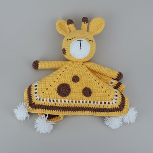 Crocheted yellow giraffe lovey blanket with brown spots and white pom-poms