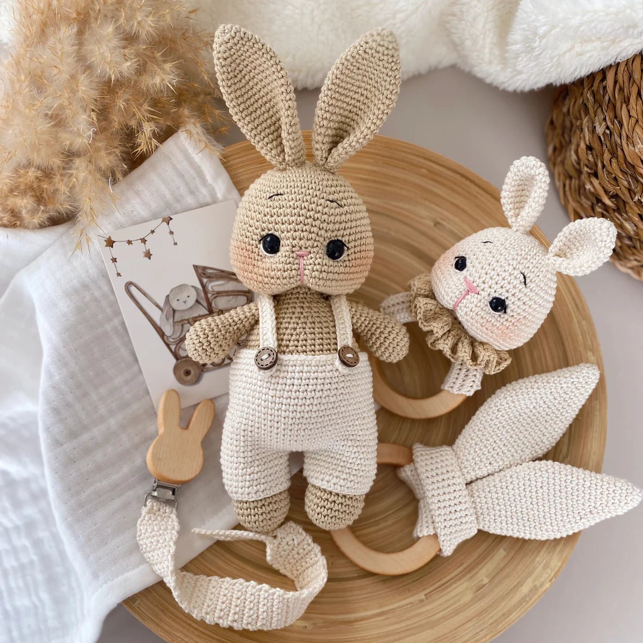 Crocheted bunny dolls in neutral tones, with pacifier clip and wooden teether