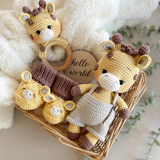 Crocheted giraffe baby toys in basket with "hello world" sign on soft blanket