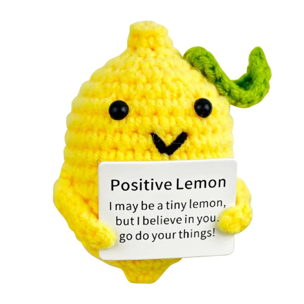 Crocheted yellow lemon character holding a motivational "Positive Lemon" sign with encouraging message