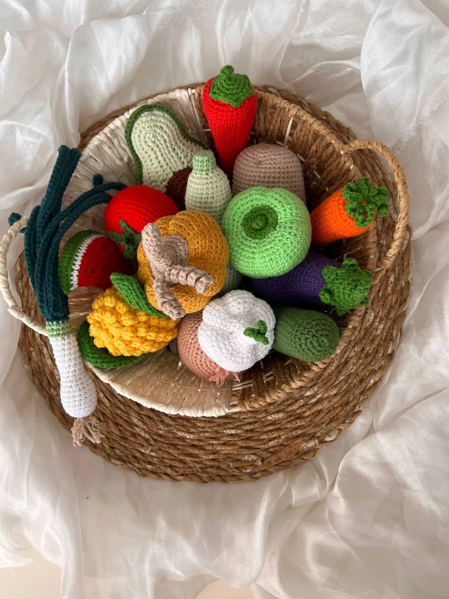 Crocheted vegetables and fruits in a woven basket, colorful and handmade craft display