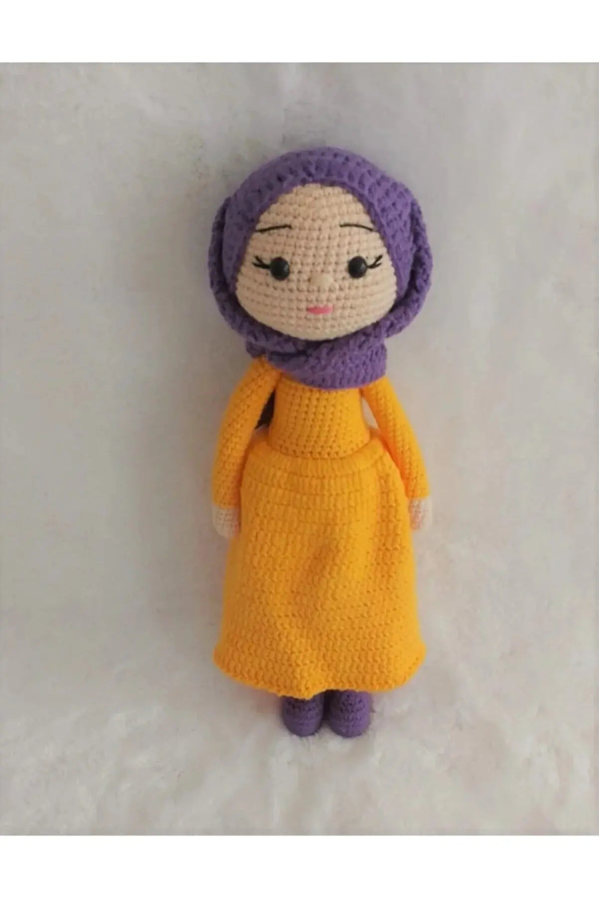 a crocheted doll wearing a yellow dress