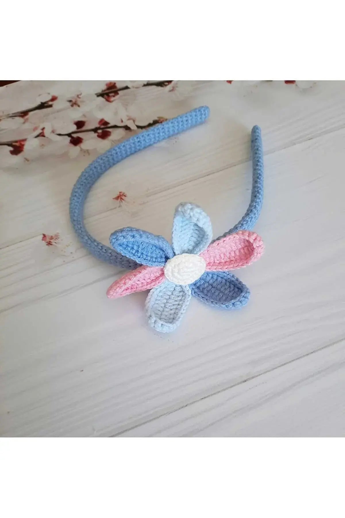 a crocheted blue and pink flower headband