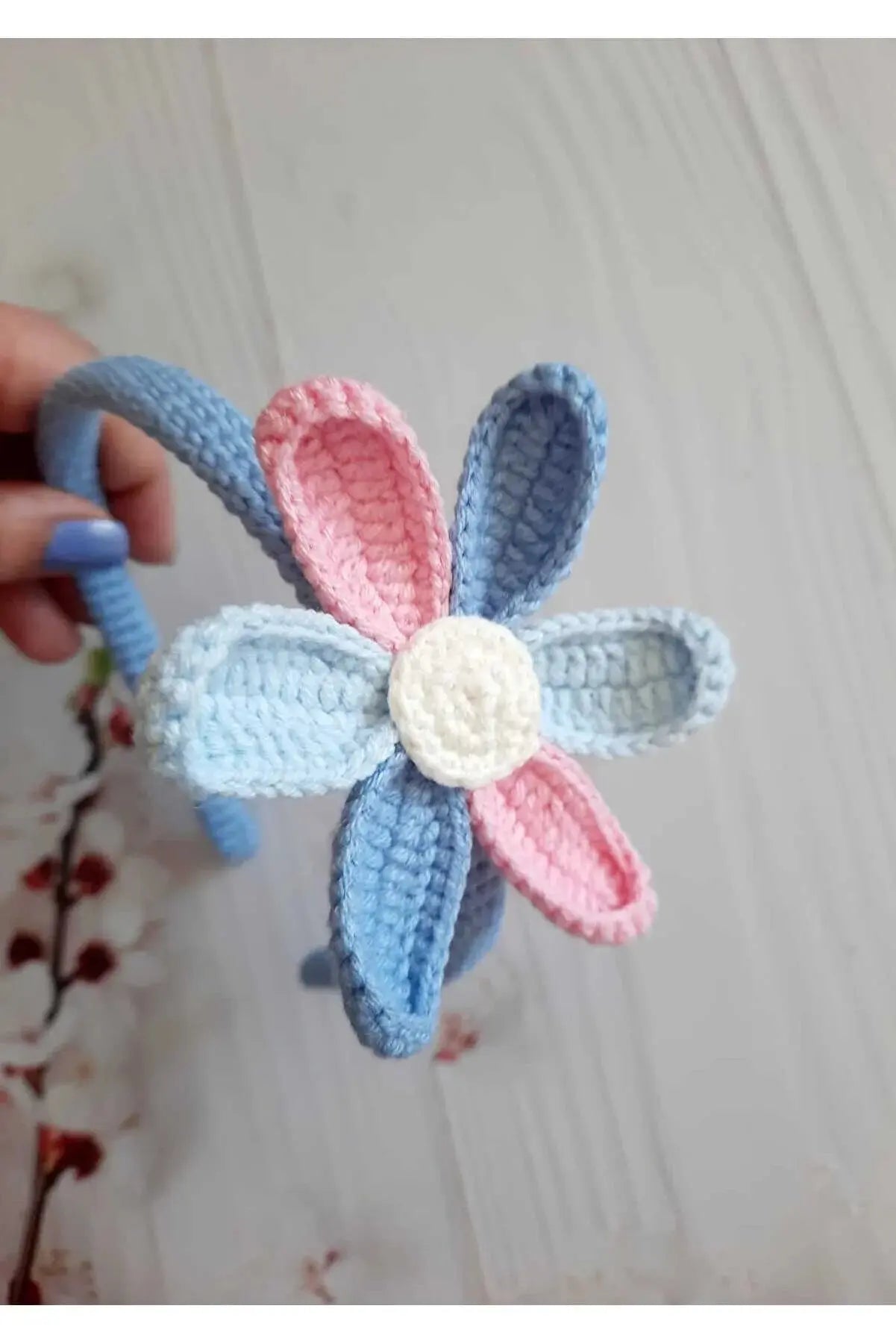 a crocheted flower being held by a person