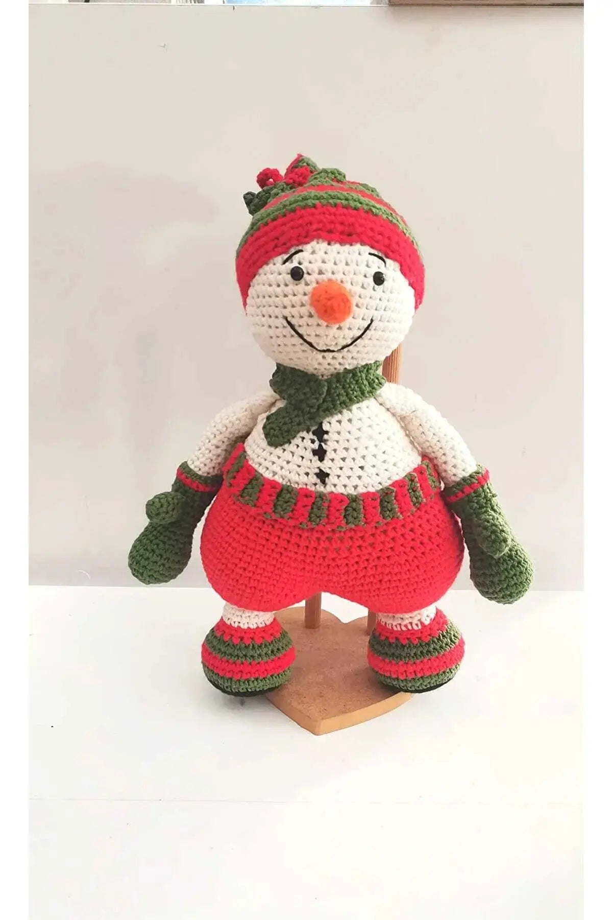 a crocheted snowman with a green hat and scarf