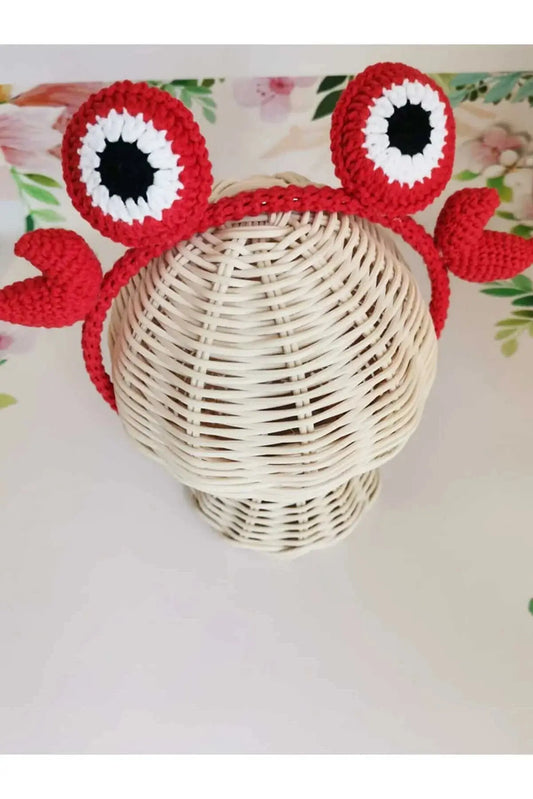 a crocheted crab hat on top of a wicker basket