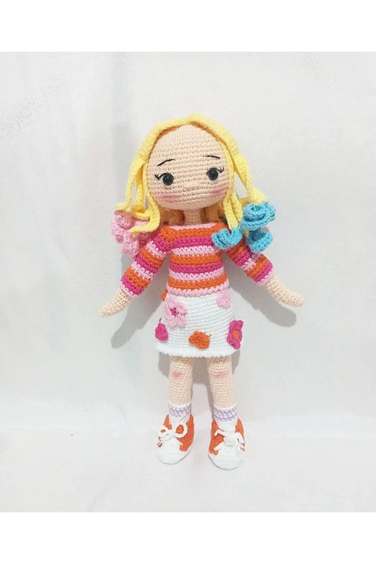 a crocheted doll with yellow hair and orange shoes