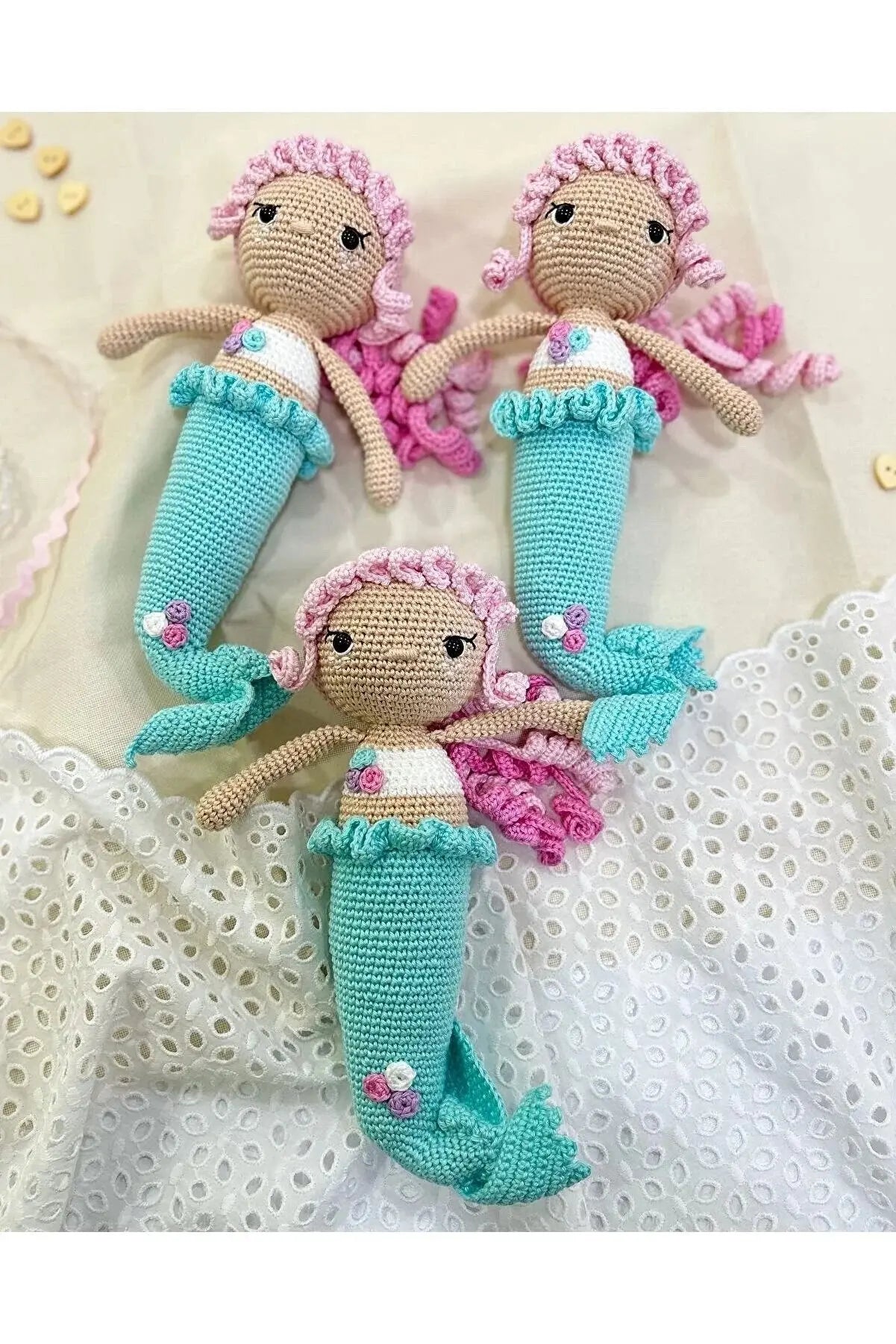 a group of three knitted mermaid dolls laying on top of a bed