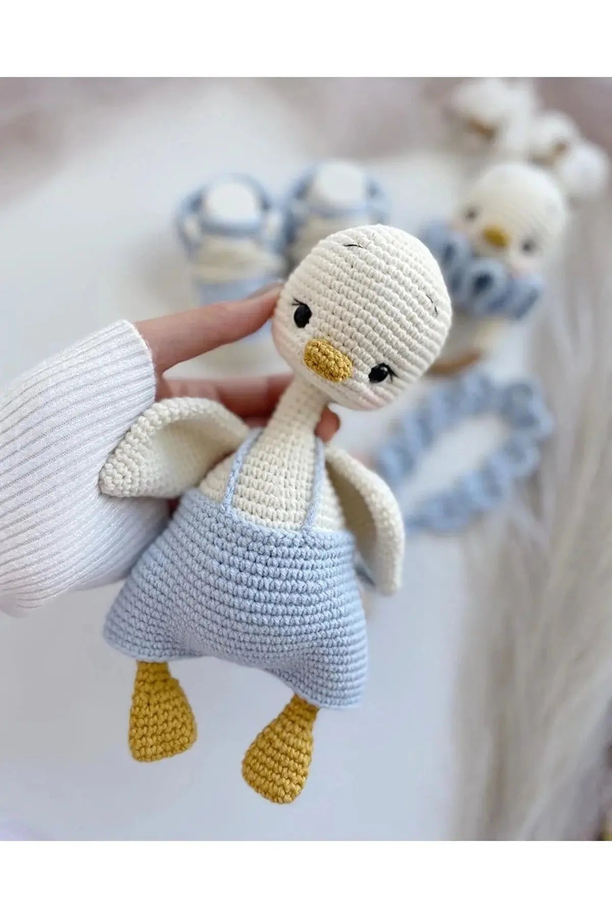 a hand holding a knitted stuffed bird