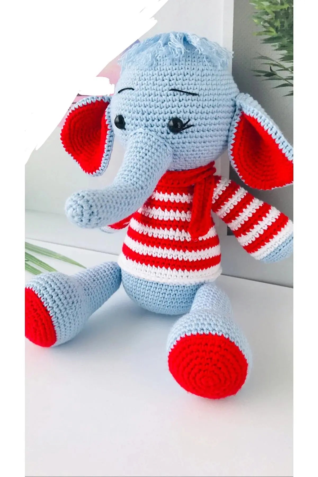 a crocheted stuffed elephant wearing a red and white striped shirt