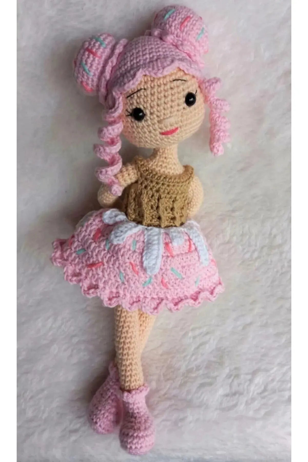 a crocheted doll with pink hair and a pink dress