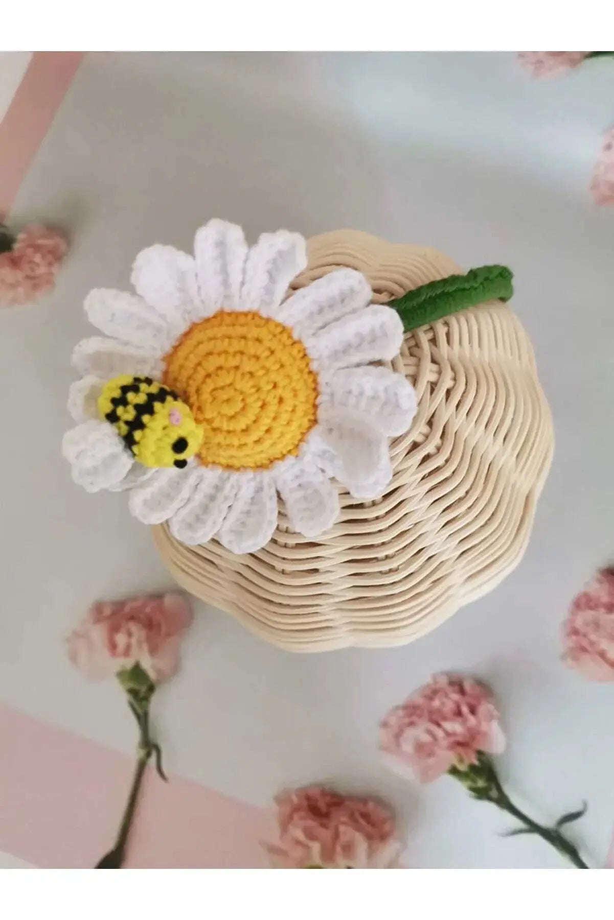 a crocheted bee sitting on top of a basket