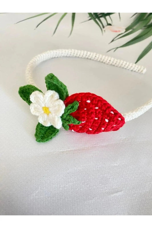 a crocheted strawberry headband with a flower on it