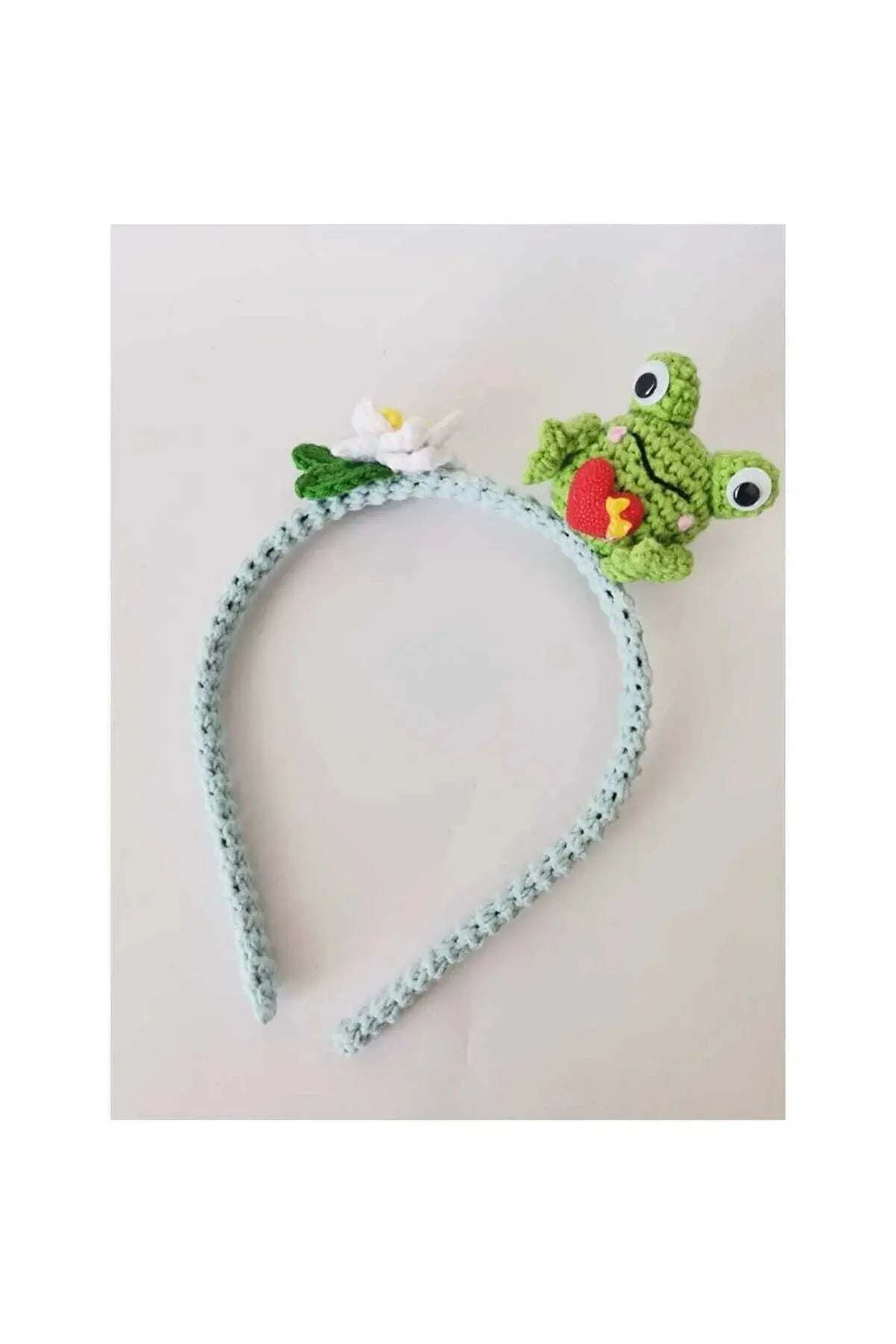 a crocheted headband with a frog on top of it