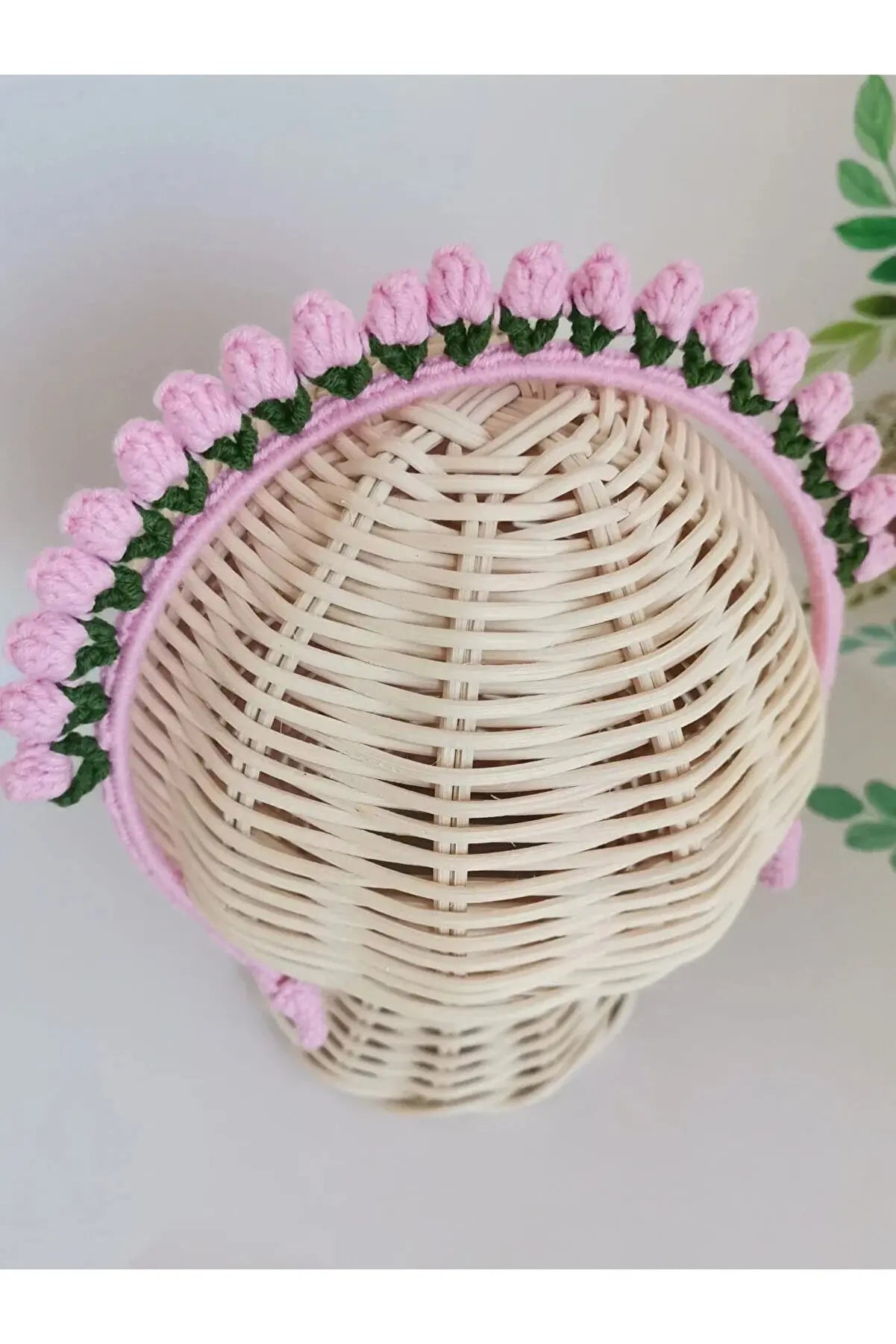 a wicker hat with pink flowers on it