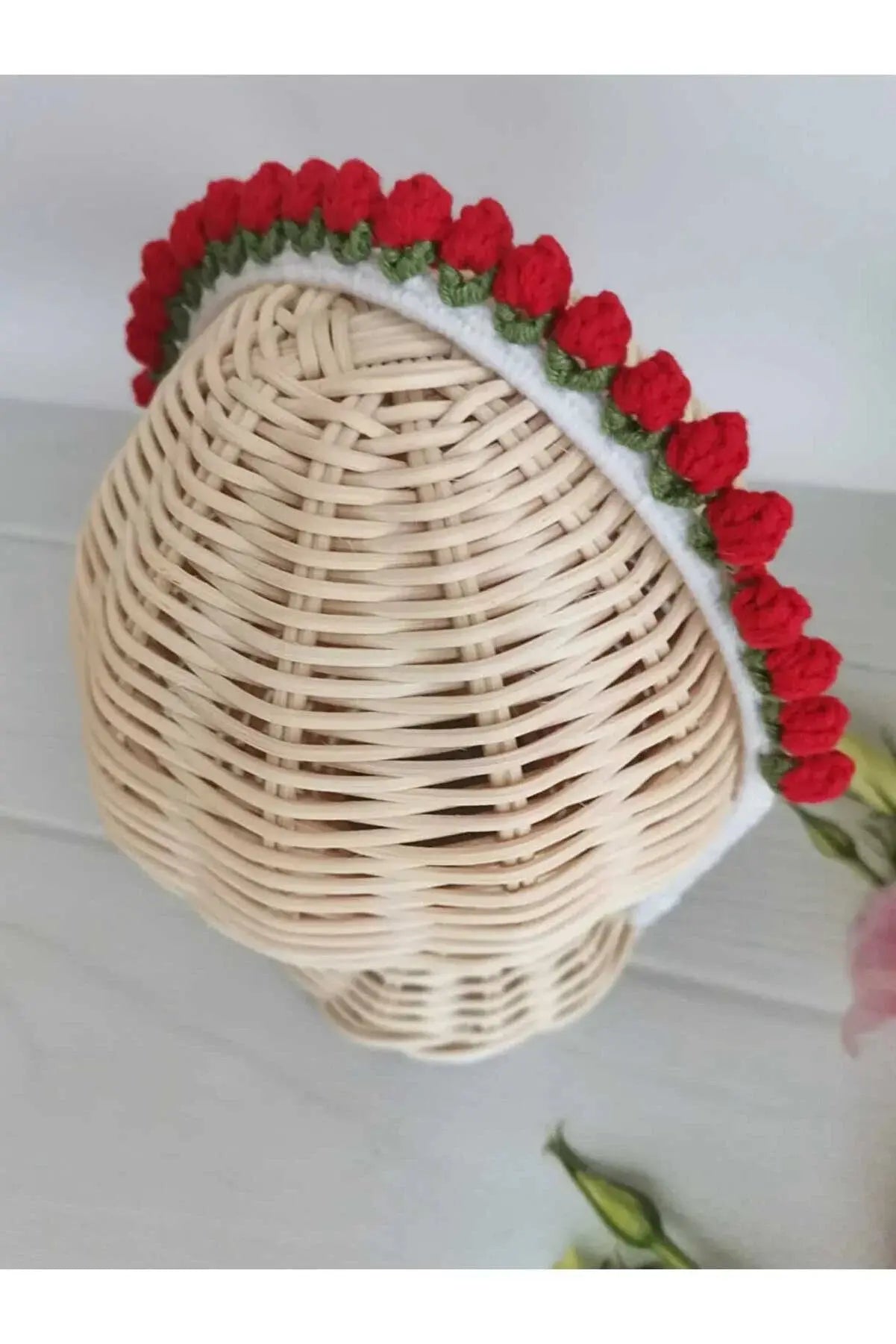 a white wicker hat with red flowers on it