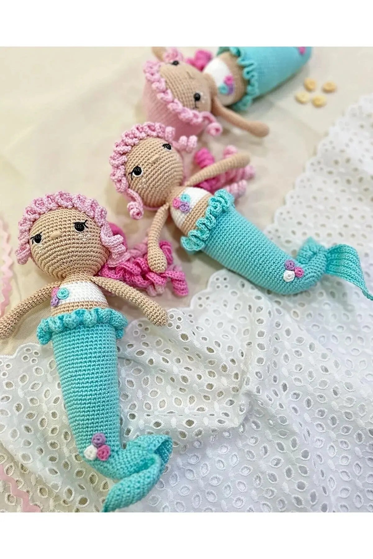 a group of knitted mermaid dolls laying on top of a bed