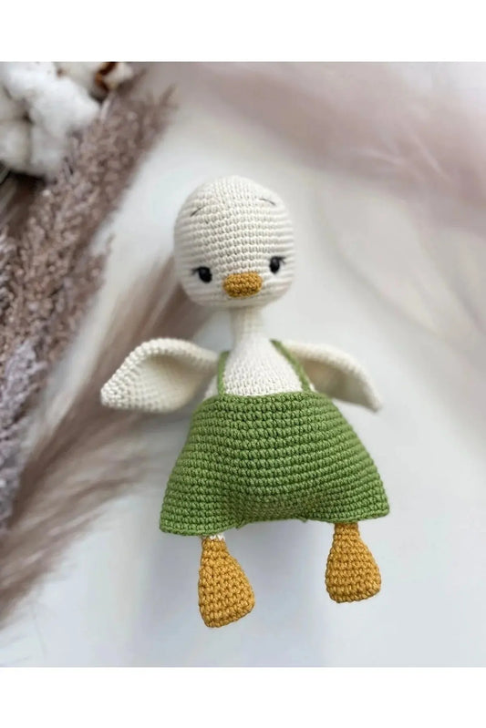 a crocheted doll of a little girl in a green dress