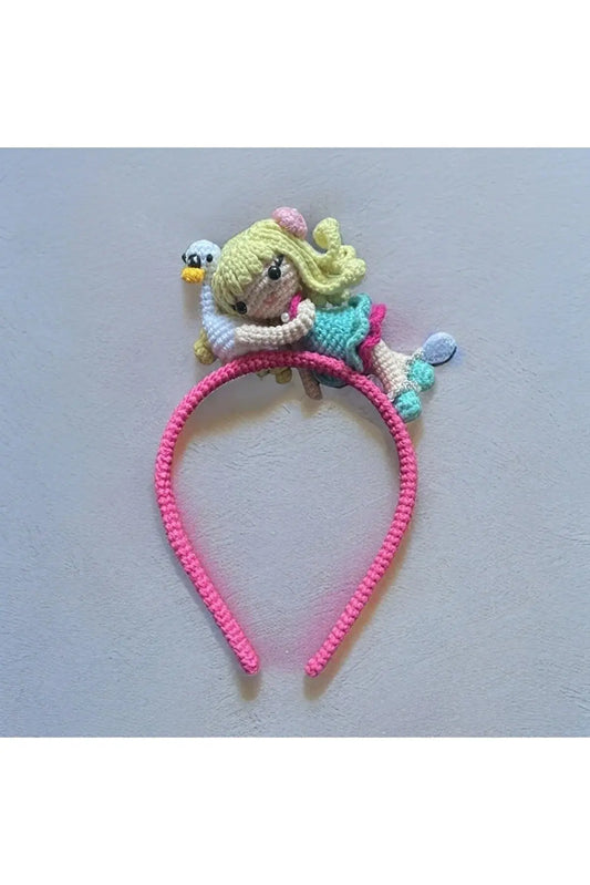 a crocheted headband with a doll on it