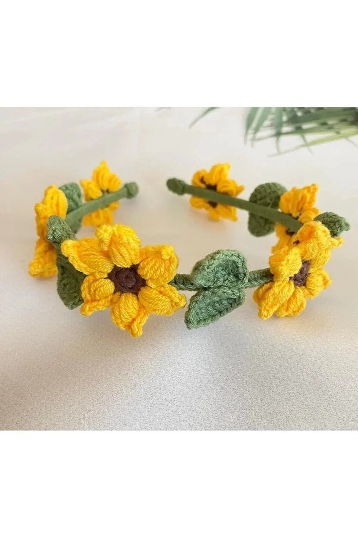 a crocheted yellow flower headband with leaves