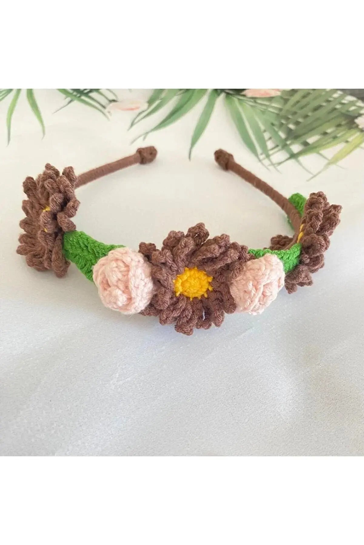 a crocheted headband with flowers on it