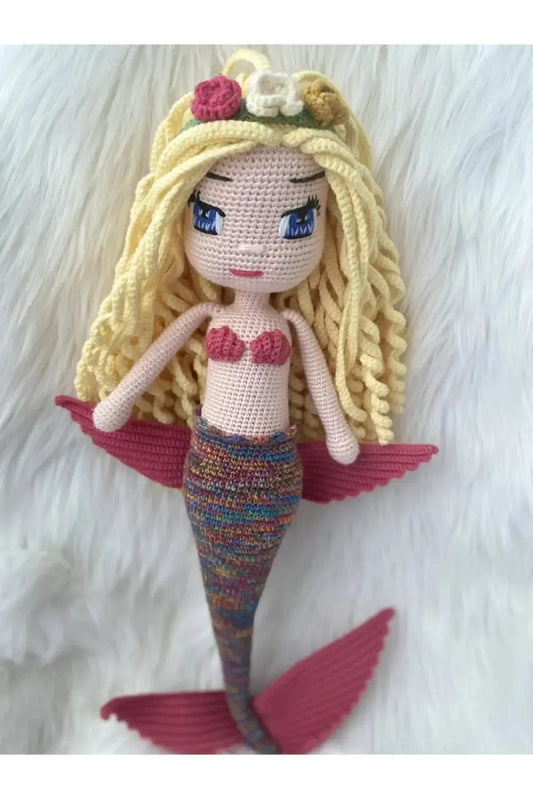 a crocheted mermaid doll with blonde hair and blue eyes