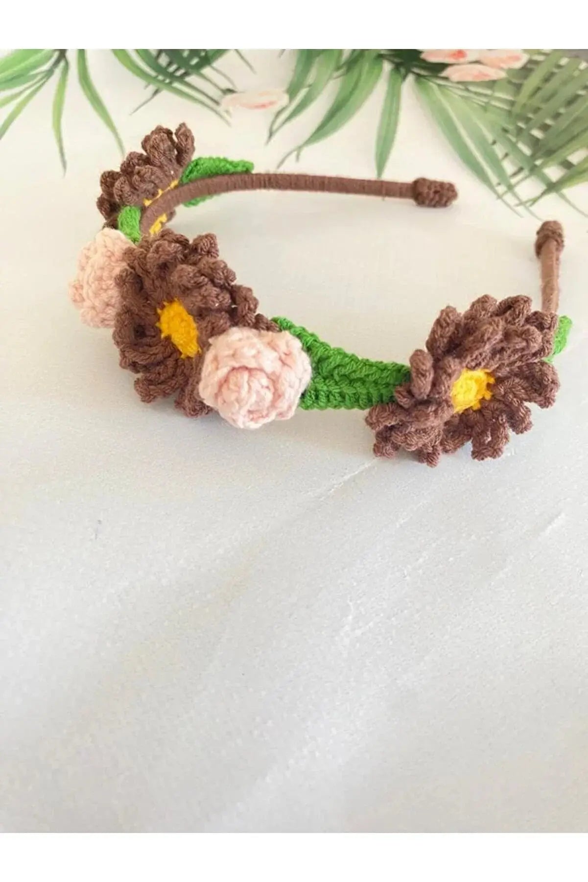 a crocheted headband with flowers on it