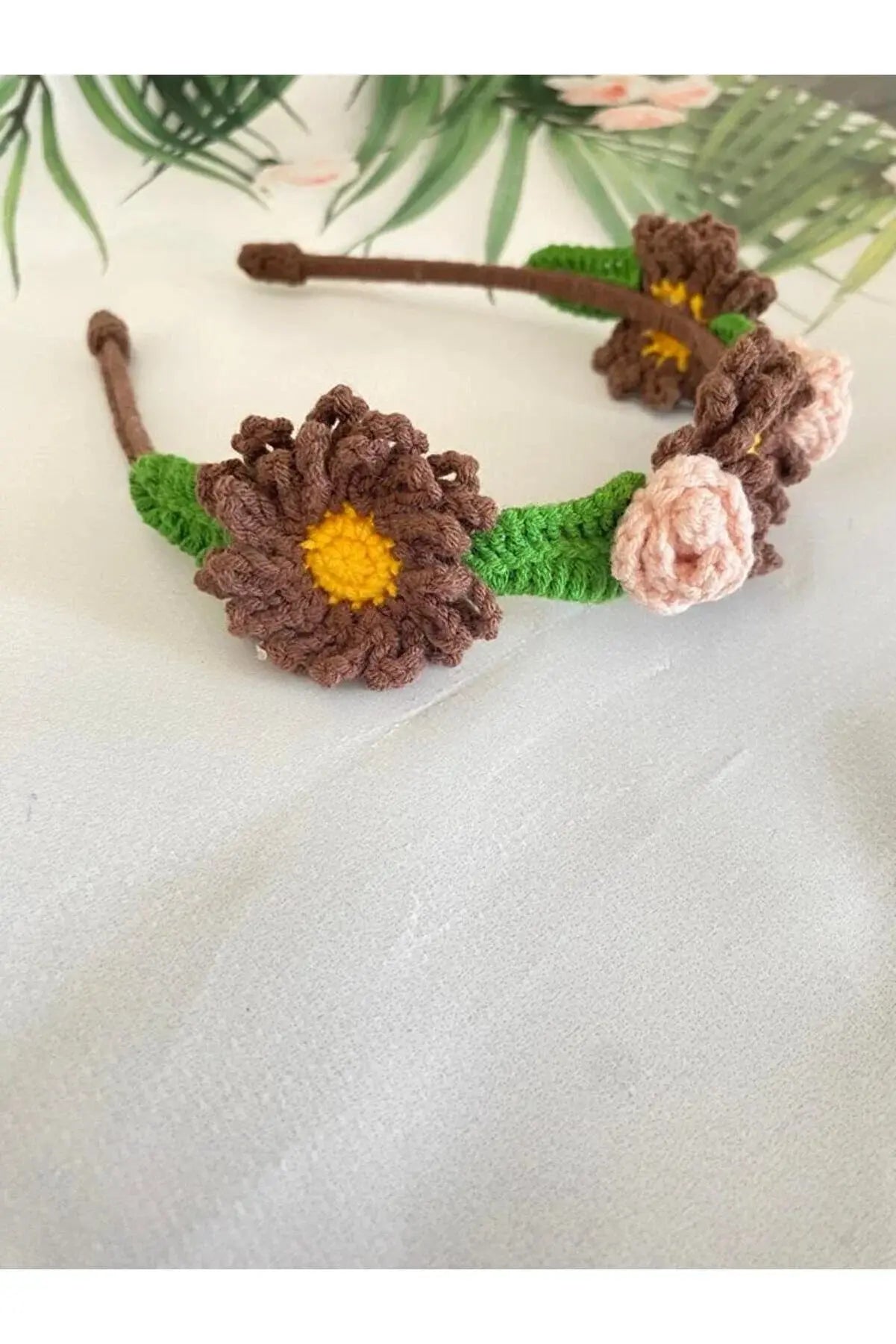 a crocheted headband with flowers on it