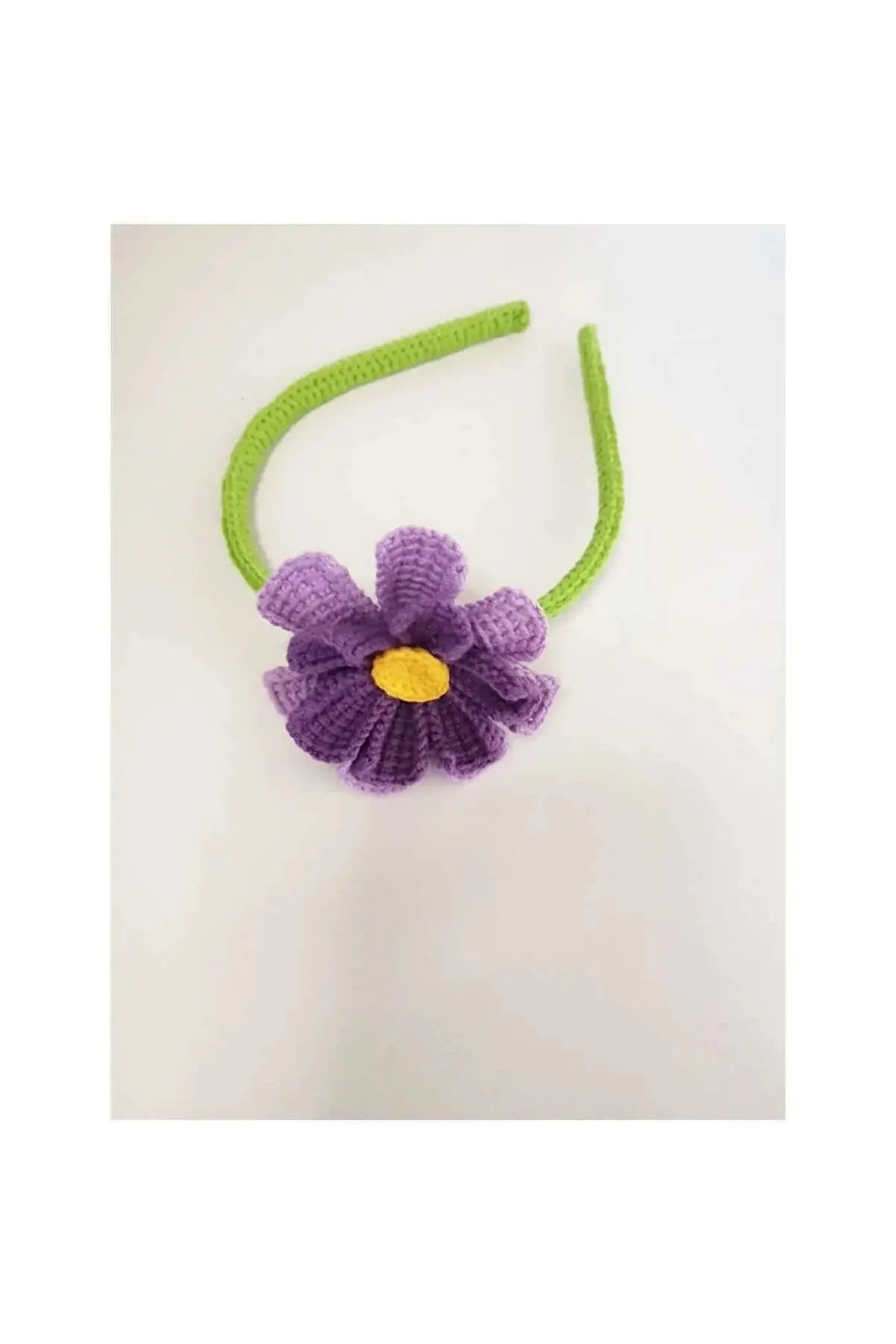 a purple and green flower on a green headband