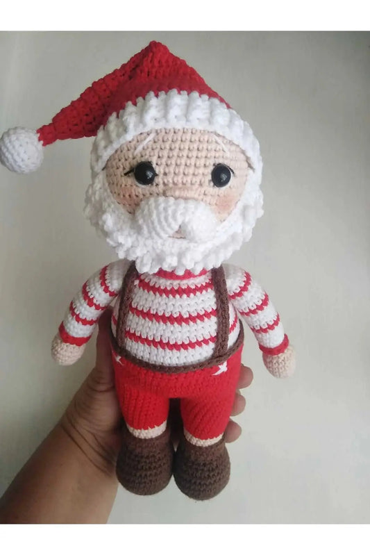 a hand holding a crocheted santa clause doll