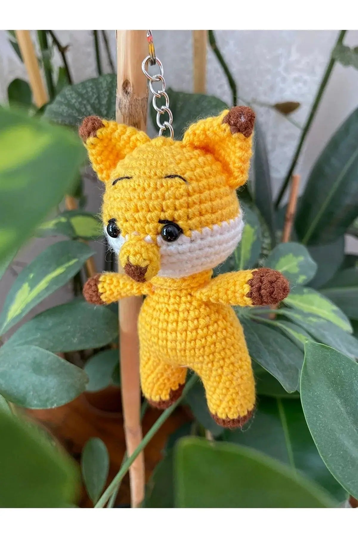 a crocheted stuffed animal hanging from a tree