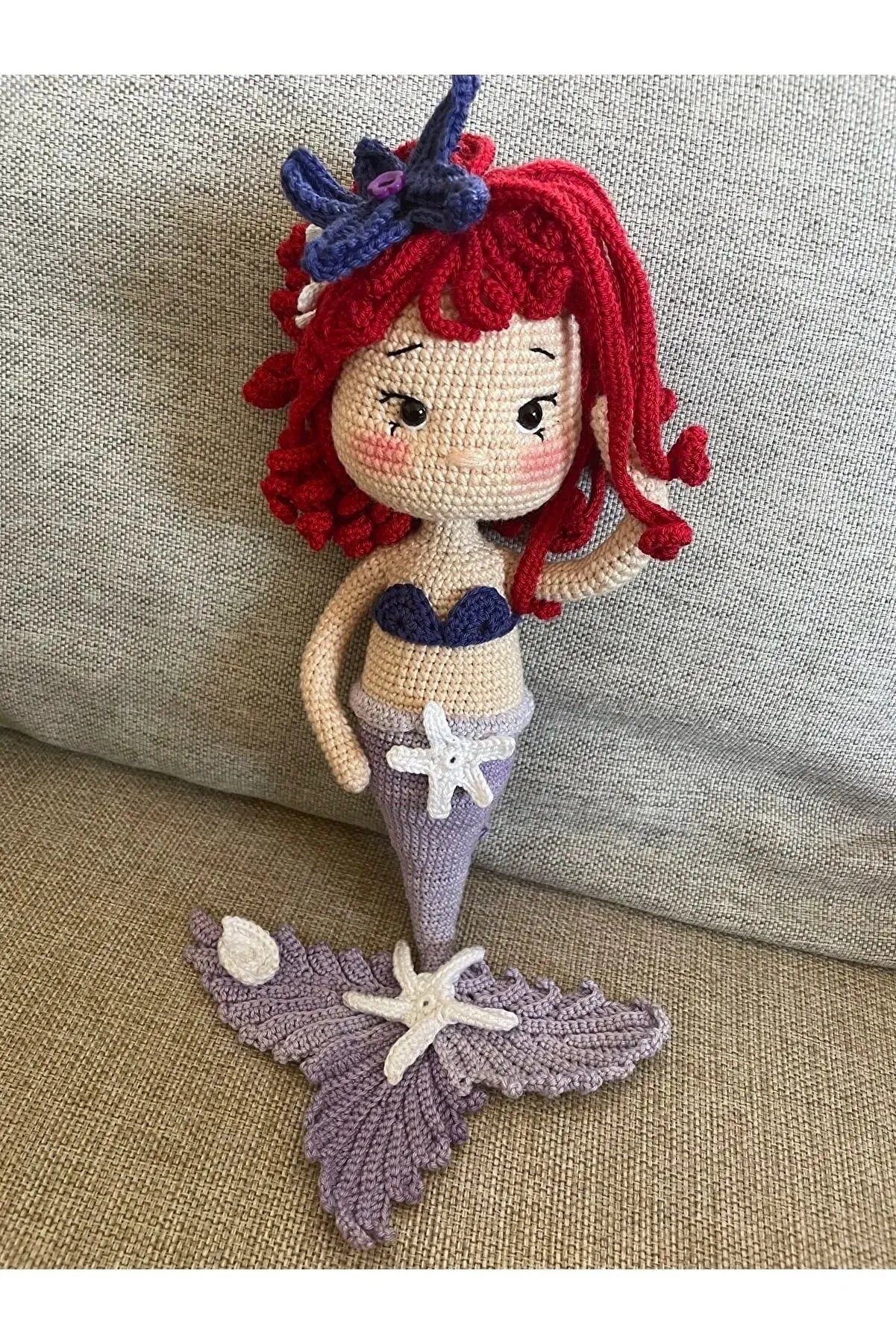 a crocheted mermaid doll sitting on a couch