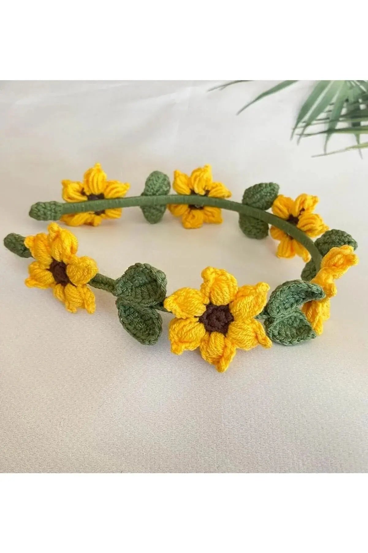 a crocheted headband with yellow flowers and leaves