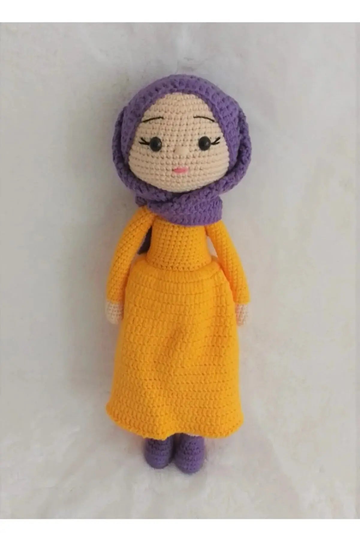 a crocheted doll wearing a yellow dress