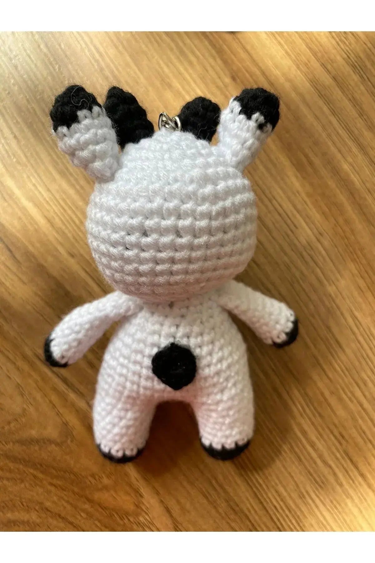 a crocheted stuffed animal sitting on top of a wooden floor