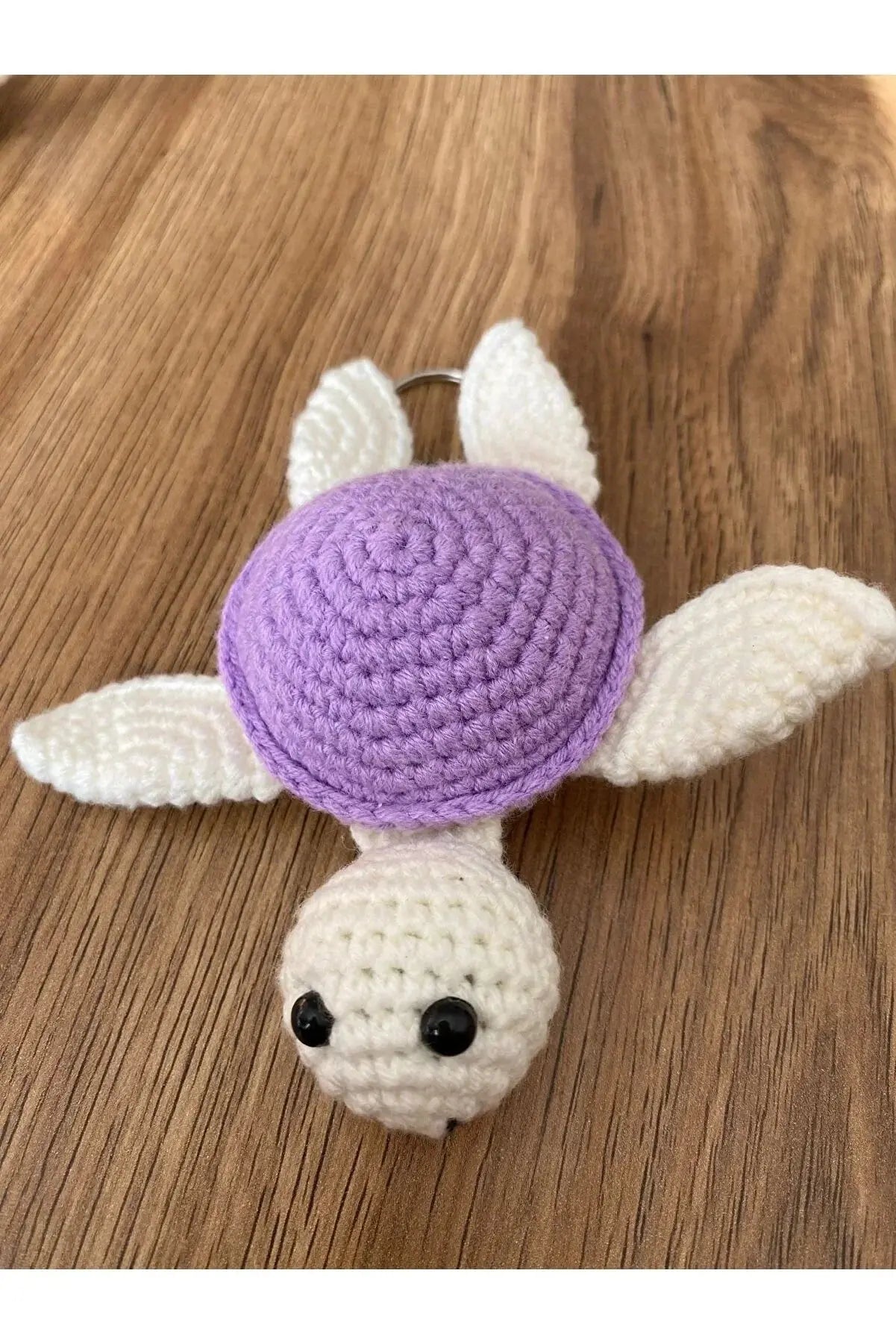 a crocheted turtle is laying on a wooden table