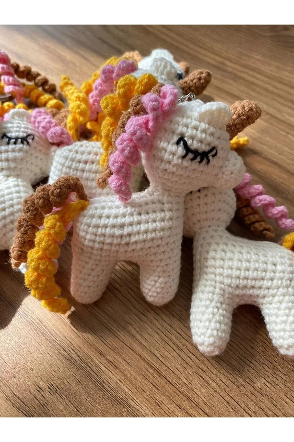 a group of crocheted unicorns sitting on top of a wooden table